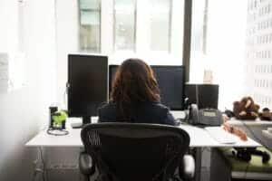 A Woman sitting in the The Best Office Chair for Back Pain at a desk