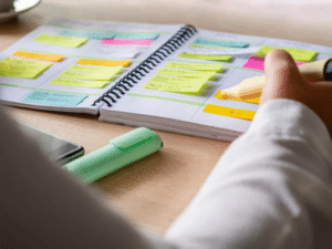 A person is using a color-coded planner to track her  habits, meals, and personal health.